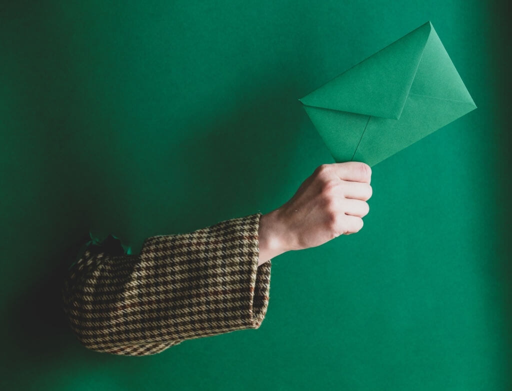 Girl's arm pulling a card out of a green background